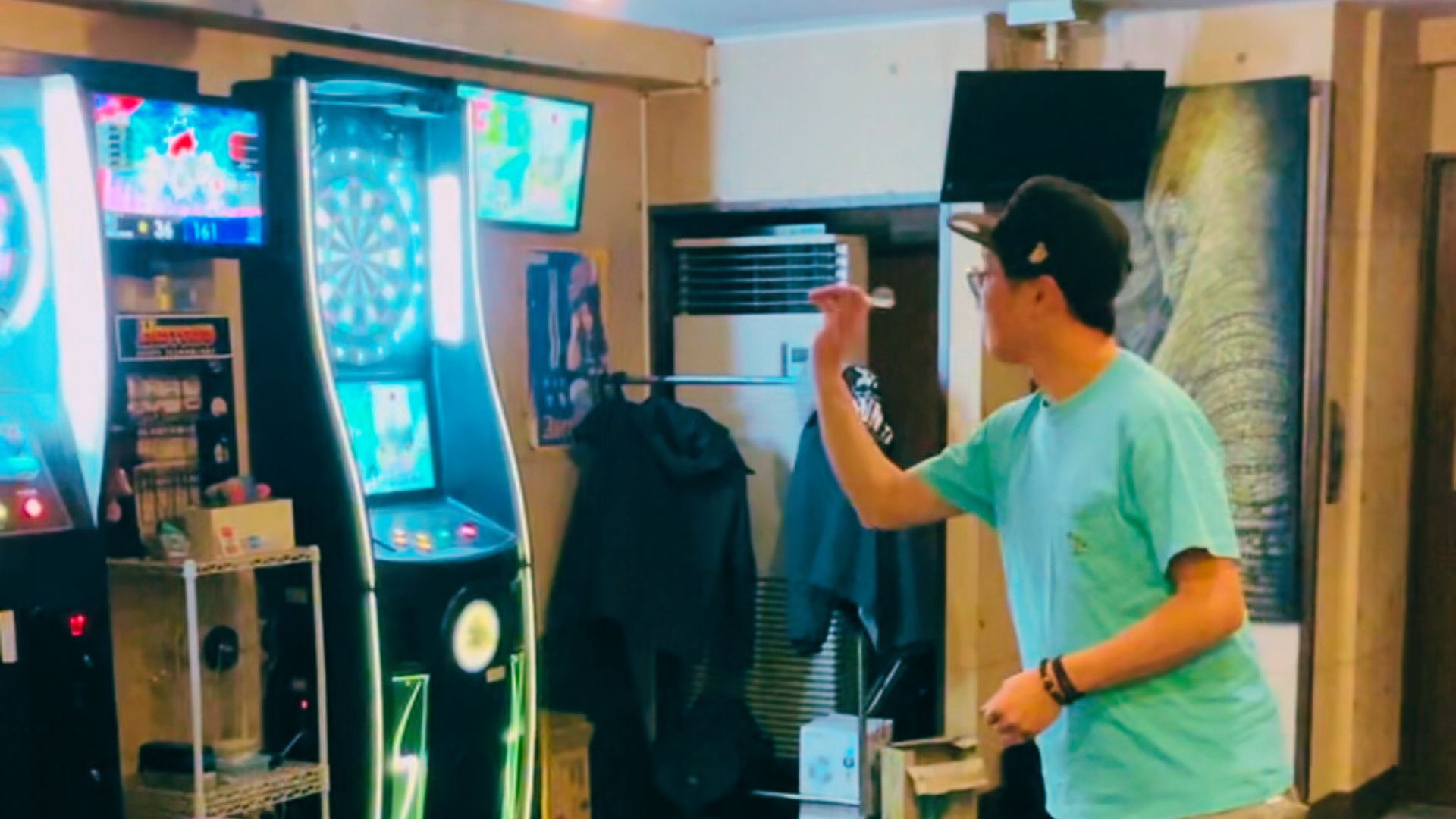 DARTSLIVE筐体でプレイする男性の姿