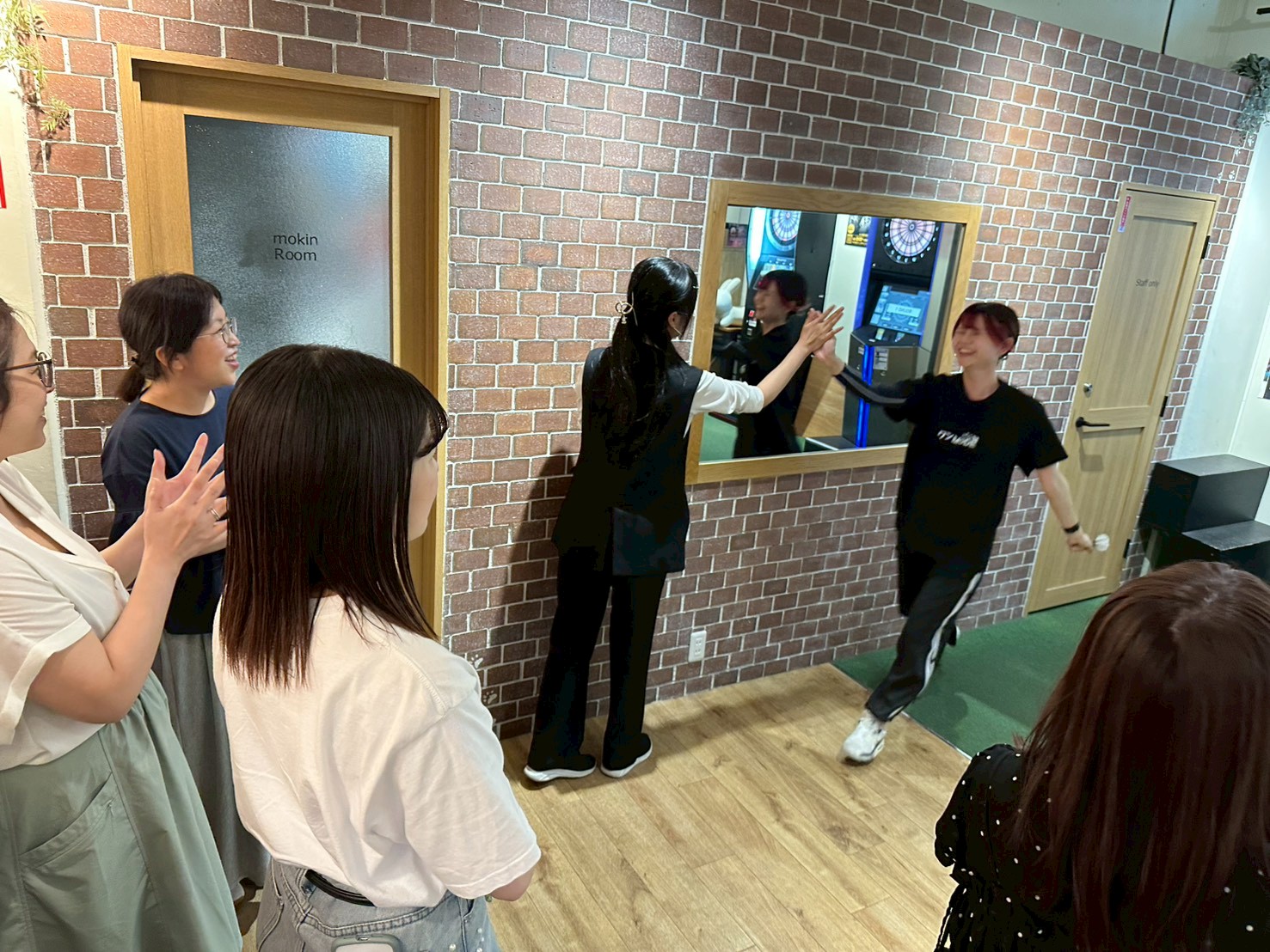 Cafe&bar trico 阿佐ヶ谷の明るい店内で、女性グループが鏡の前で楽しそうに交流している様子。